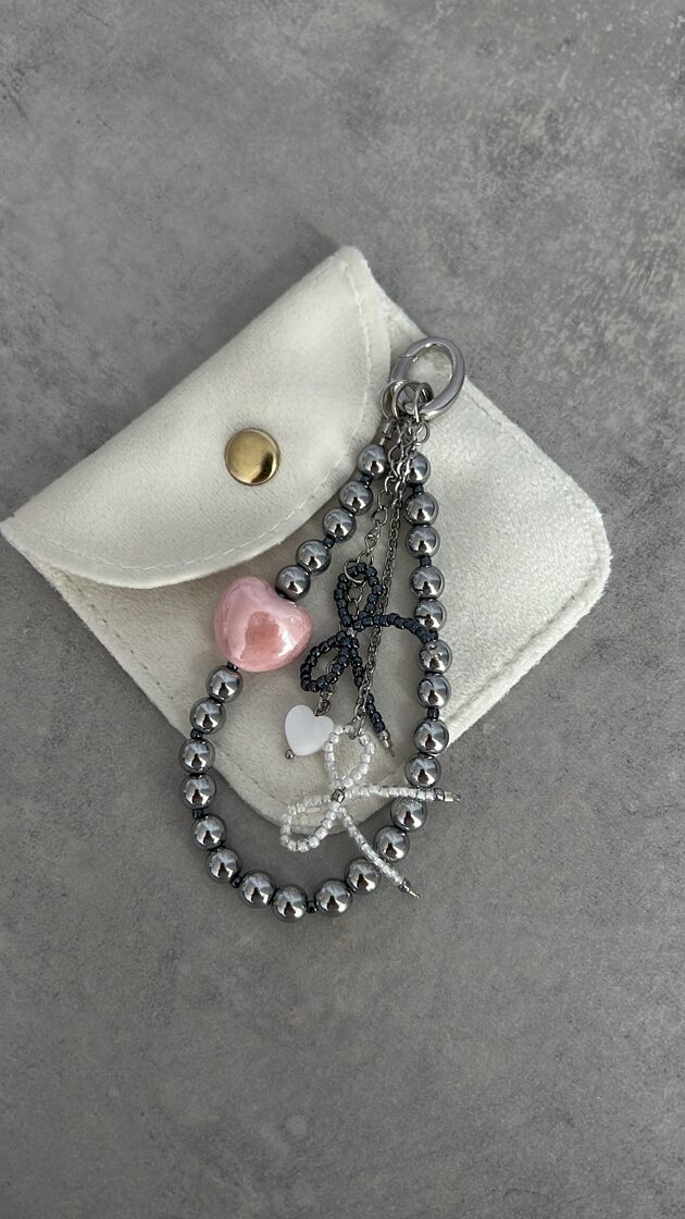 Hematīta ķēde ar gludām, spīdīgām akmens pērlītēm un metāla elementiem.