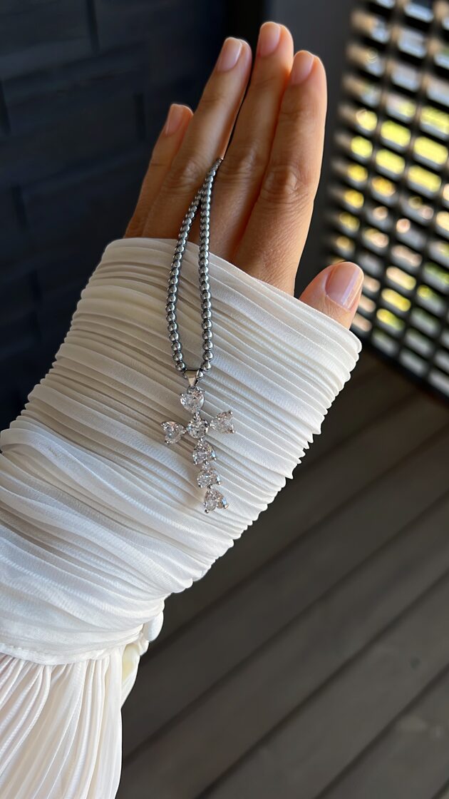 Hematīta chokers ar lielu krustu, elegants un moderns aksesuārs.