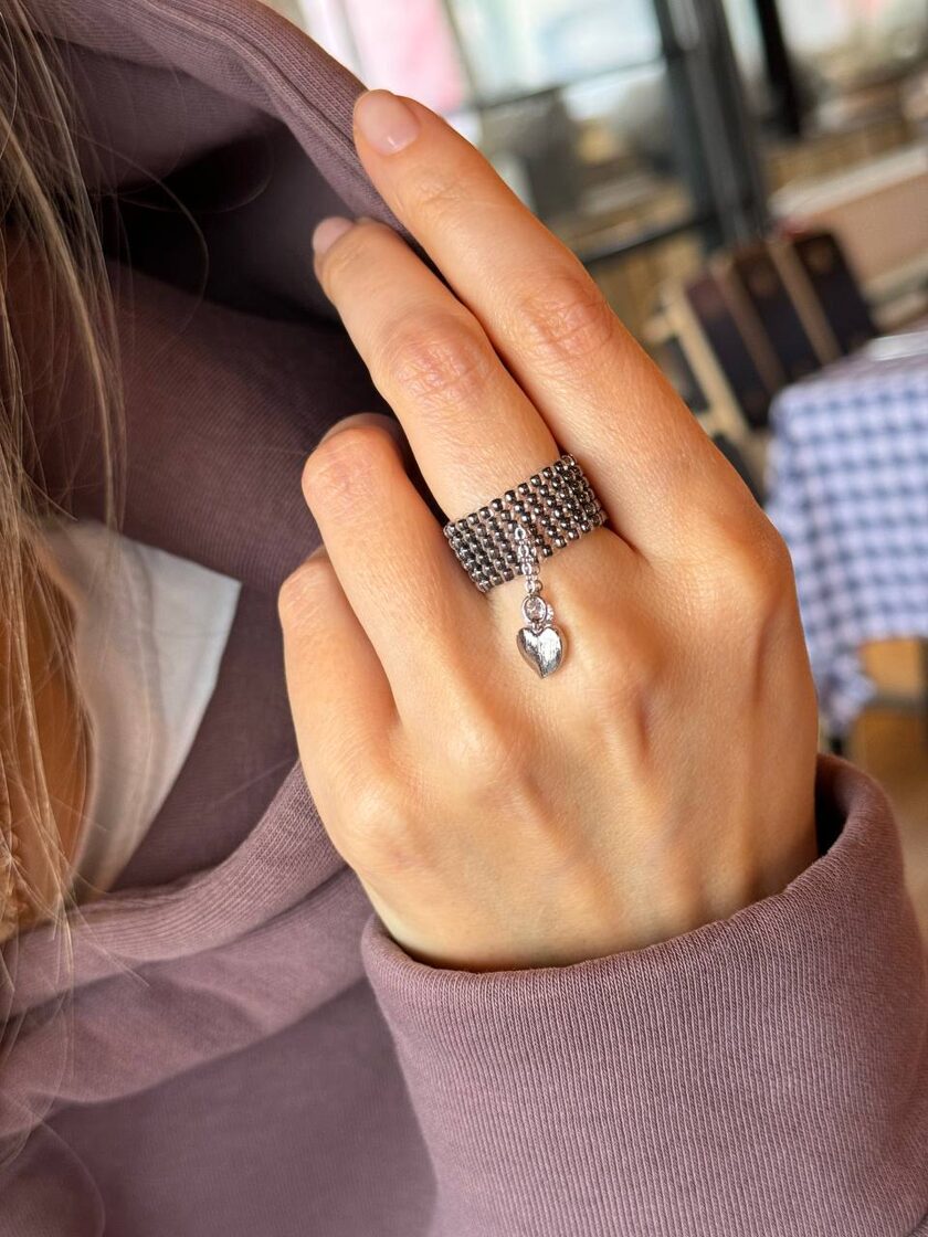 Grafīta kulons ar sirdi un mazu akmeni, elegants un izsmalcināts rotājums.