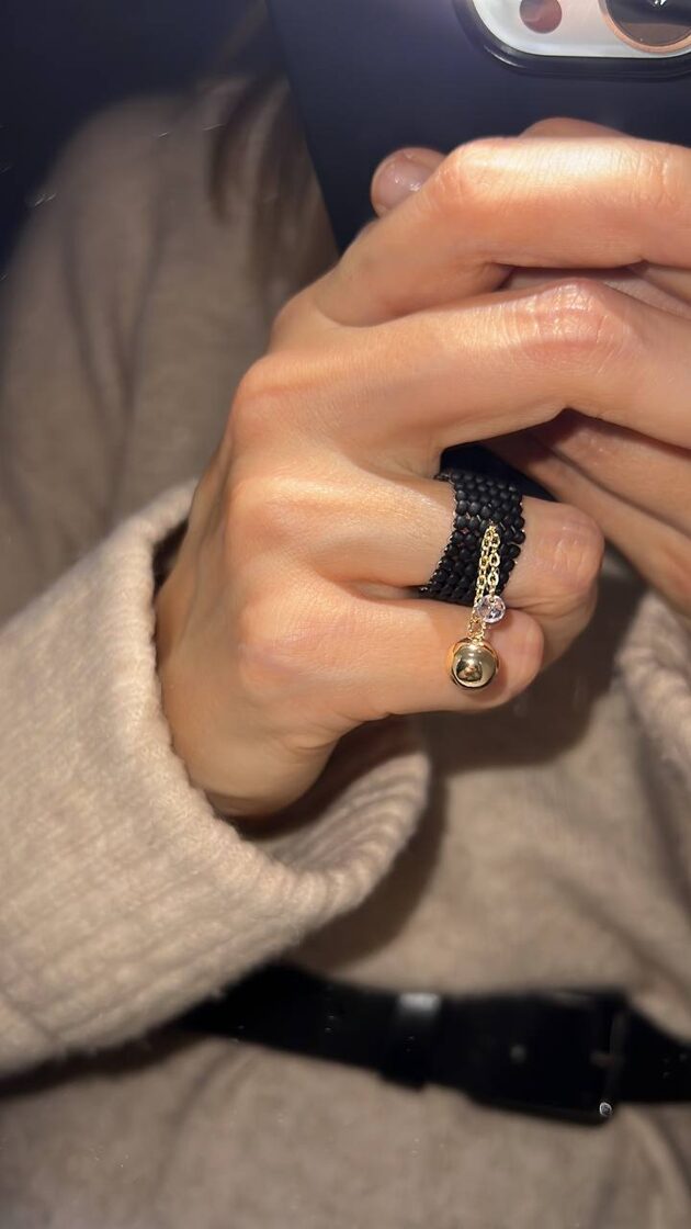 Melnā matētā virsma ar sfēru un akmeni, veidojot elegantu un modernu dizainu.