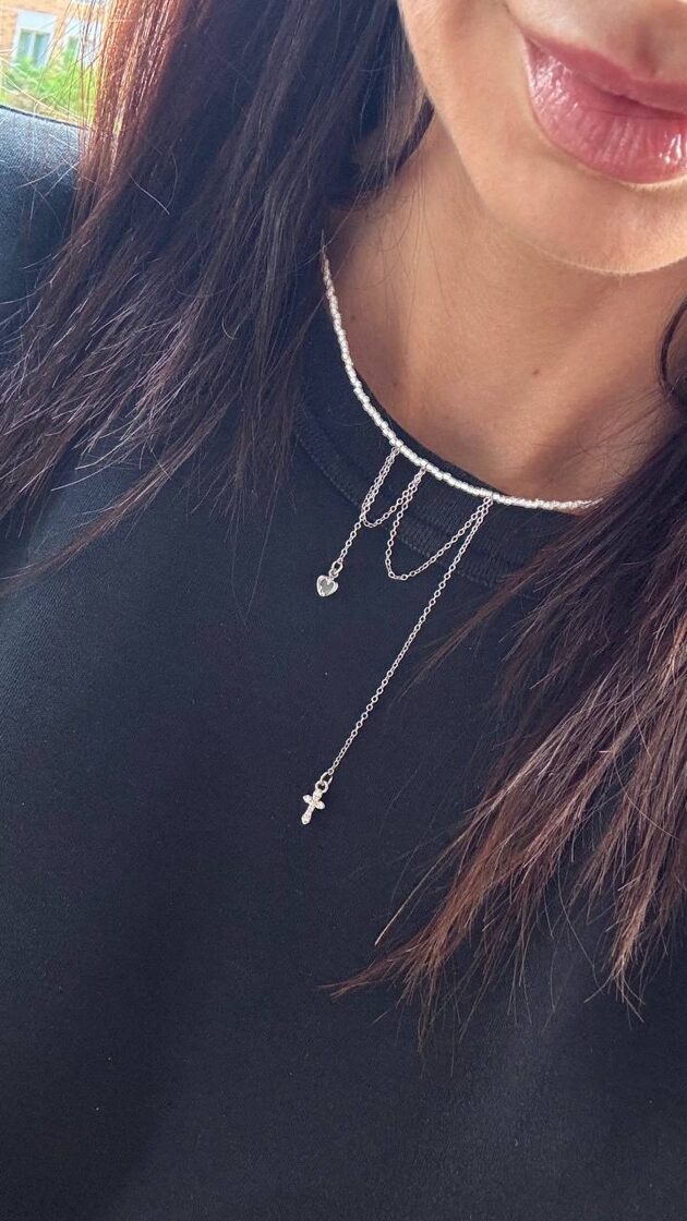 Balts pērļu chokeris ar mazu krustu un sirdi, elegants un stilīgs aksesuārs.