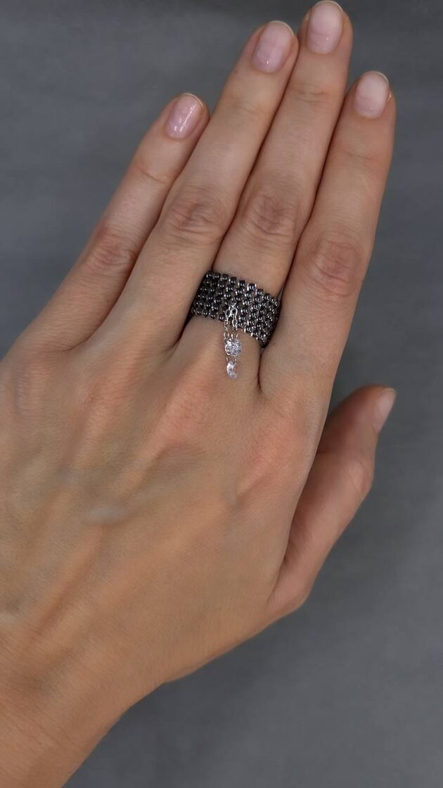 Grafīta rotaslieta ar divām mazām akmeņiem, kas piešķir elegantu izskatu.