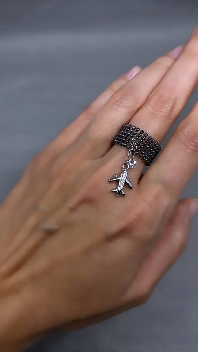 Grafīta krāsas dekoratīvais elements ar plakanu un mazu akmeni.